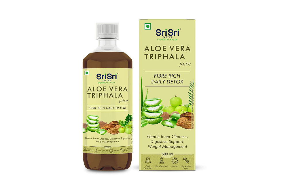 Bottle of Triphala with Aloe Vera Ras alongside fresh aloe vera and dried Triphala fruits