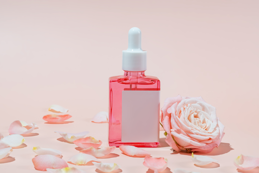 Rose water toner bottle with fresh rose petals and cotton pads